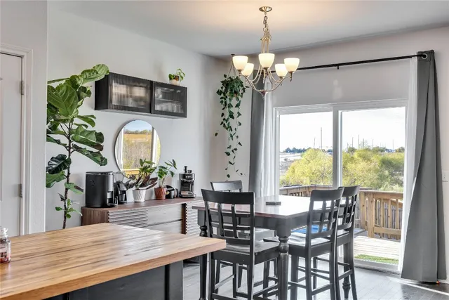 a view of a dining room with furniture a chandelier and wooden floor