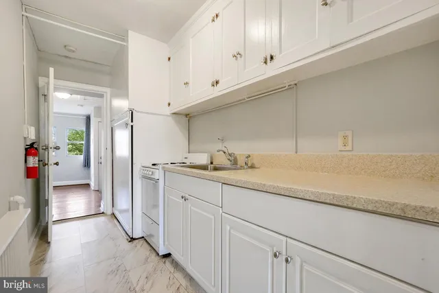 a kitchen with granite countertop a stove and a sink