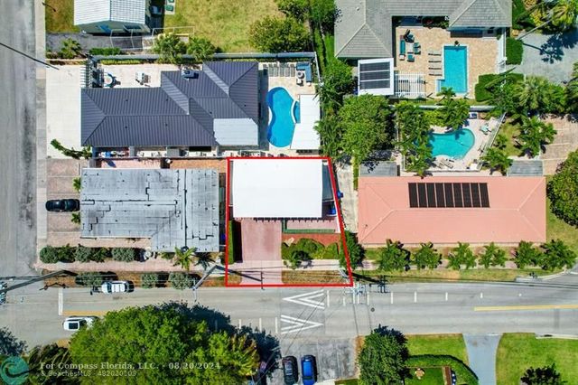 a front view of a house with a yard and potted plants