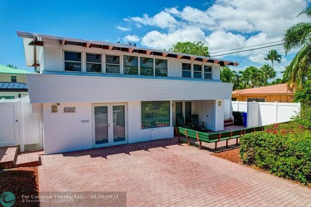 a front view of a house with a yard and potted plants