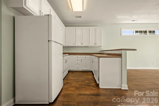 a utility room with wooden floor washer and dryer