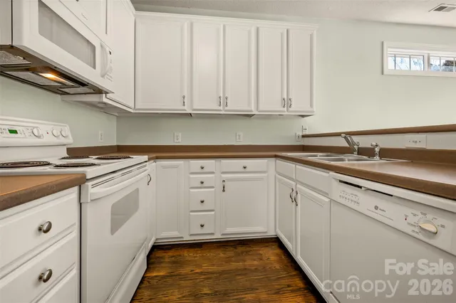 a kitchen with white cabinets and white appliances