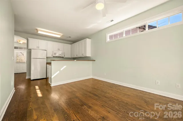 a view of kitchen with refrigerator and wooden floor