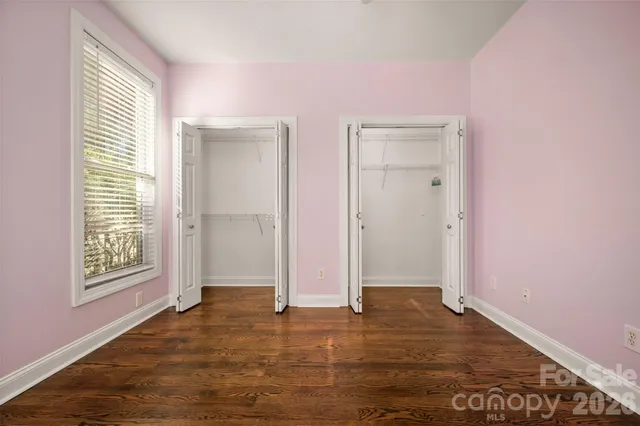 an empty room with windows and closet