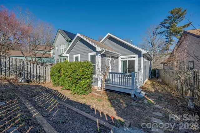 a view of a house with a yard and wooden fence