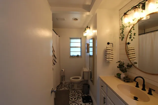 a bathroom with a sink and mirror with toilet