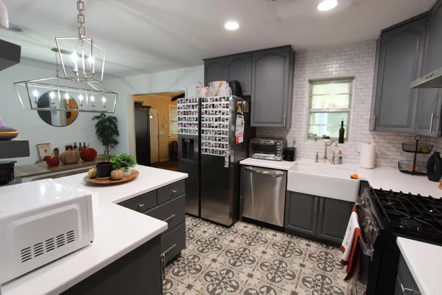 a kitchen with stainless steel appliances granite countertop a sink stove and refrigerator