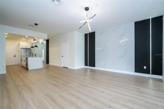 a view of an empty room with wooden floor and cabinet