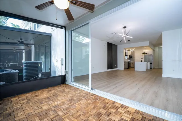 a view of a hallway with wooden floor and chandelier