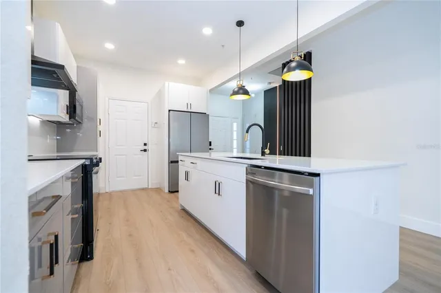 a kitchen with a sink stainless steel appliances and cabinets