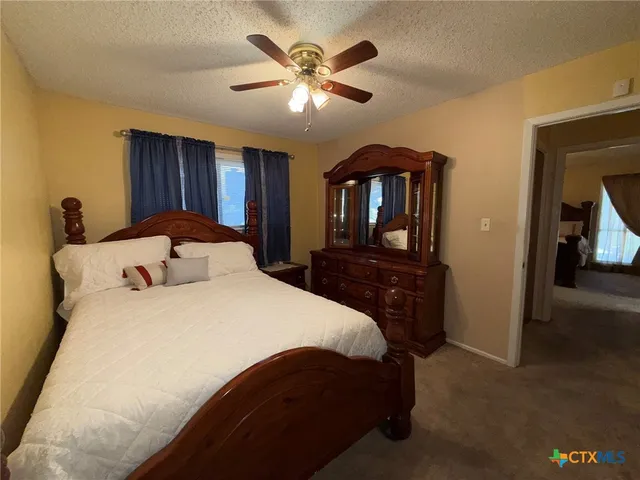 a bedroom with a large bed and a chandelier