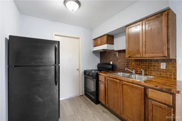 a kitchen with stainless steel appliances granite countertop a refrigerator a sink and a stove
