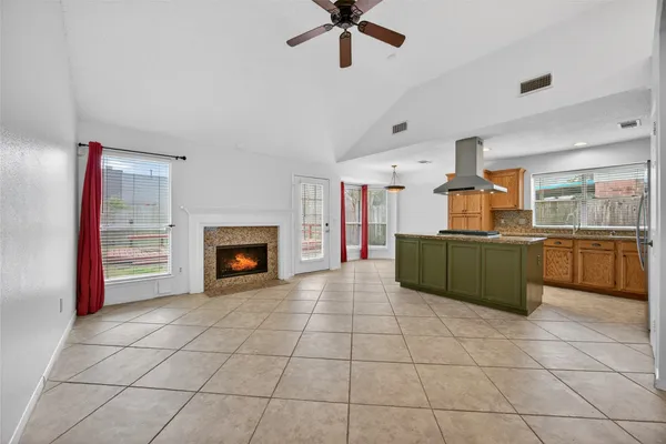 a view of a kitchen with an empty room and a fireplace