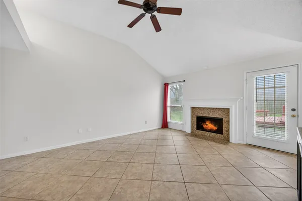 a view of an empty room with a fireplace and a window