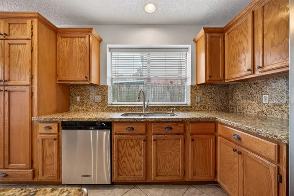 a kitchen with stainless steel appliances granite countertop a sink and a window