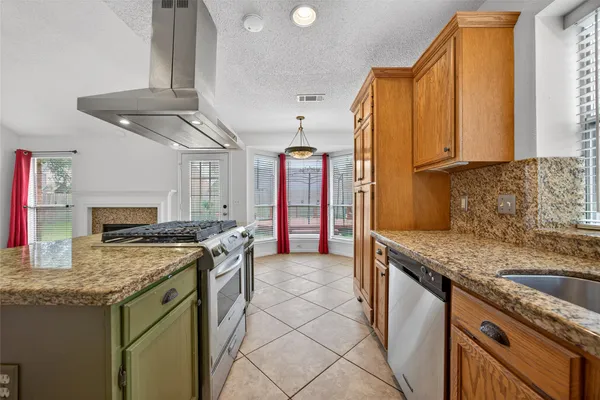 a kitchen with stainless steel appliances granite countertop a sink a stove and a refrigerator