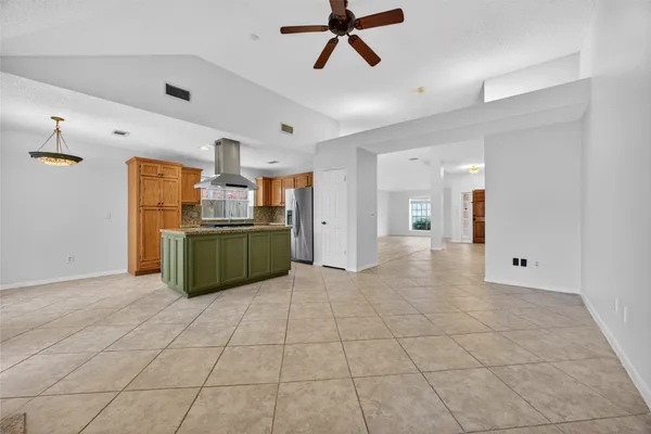 a kitchen with stainless steel appliances kitchen island granite countertop a refrigerator and a sink