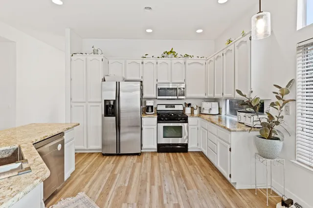 a kitchen with stainless steel appliances a stove refrigerator sink and microwave