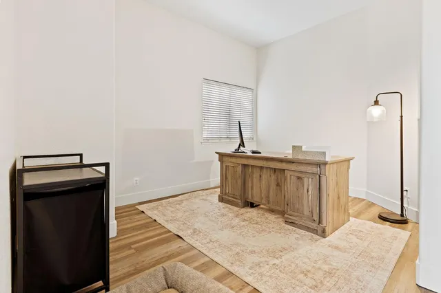 a view of a hallway with wooden floor and staircase