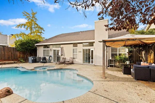 a view of a house with swimming pool and sitting area