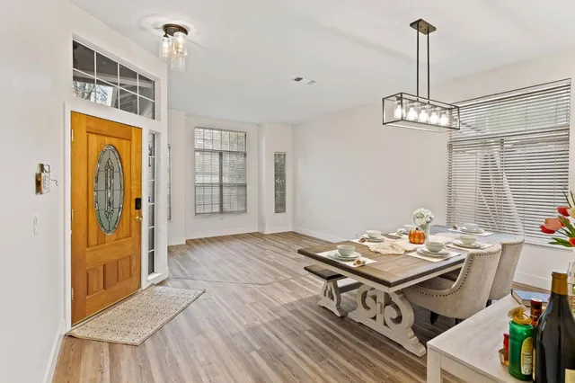 a living room with stainless steel appliances furniture a chandelier and a table