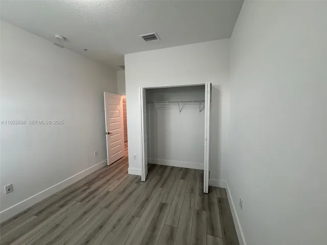a view of a hallway with wooden floor and stairs