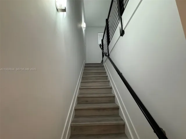 an empty room with wooden floor cabinet and windows