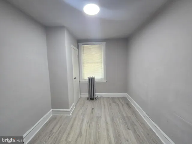 a view of a room with wooden floor and a window