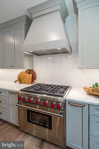 a kitchen with stainless steel appliances kitchen island granite countertop a table chairs sink and cabinets
