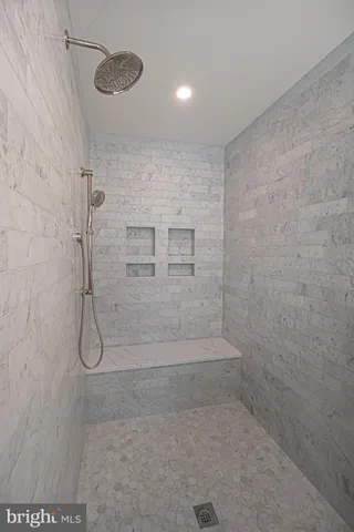 a white bath tub sitting in a bathroom next to a window