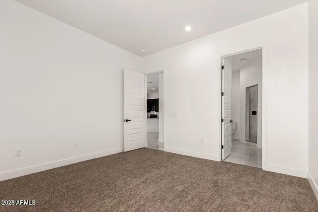 an empty room with closet and windows