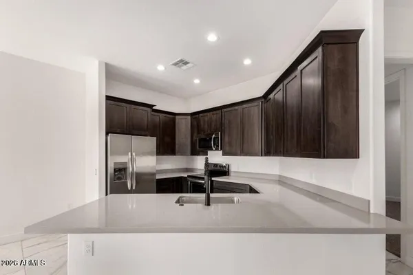 a kitchen with kitchen island a sink and a refrigerator