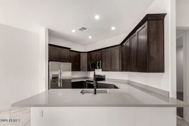 a kitchen with kitchen island a sink and a refrigerator