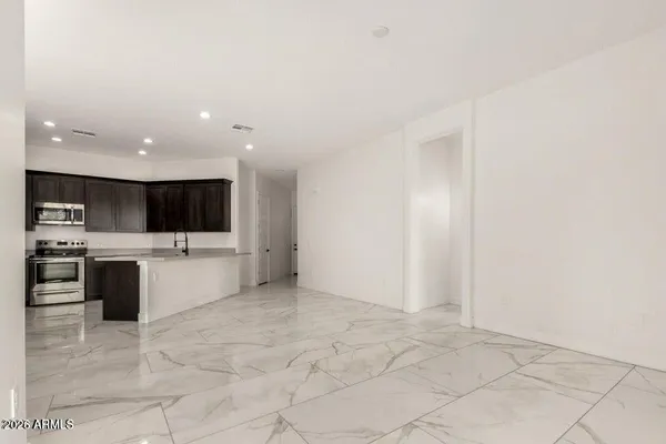 a view of an empty room with kitchen