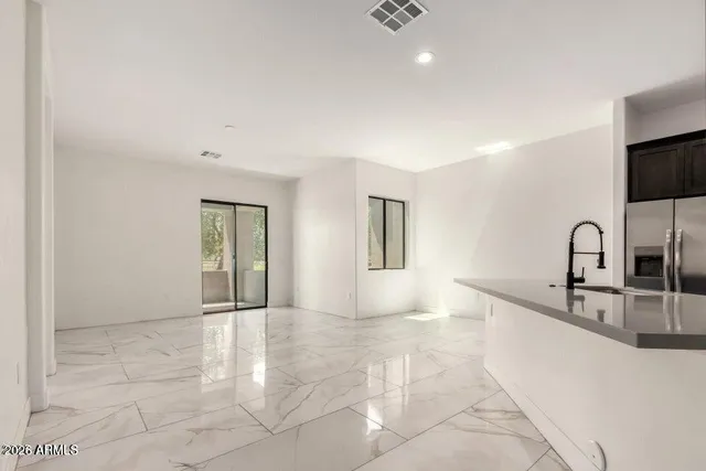 a view of a kitchen with granite countertop a sink and a stove top oven