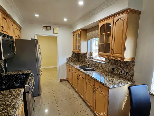a kitchen with stainless steel appliances granite countertop a stove a sink and a refrigerator