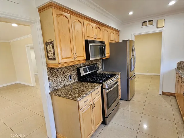 a kitchen with stainless steel appliances granite countertop a refrigerator stove and sink