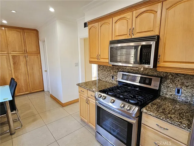 a kitchen with granite countertop cabinets stainless steel appliances and a counter space