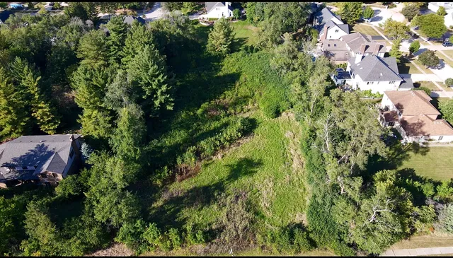 an aerial view of residential house with outdoor space and trees all around
