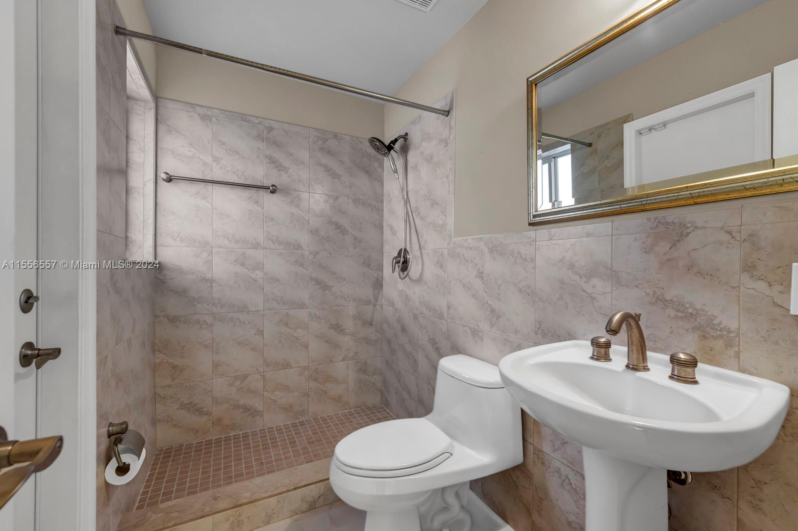 4014 Southwest 144th Place Miami, FL 33175 - Photo 19 of 50 a bathroom with a sink a toilet and shower