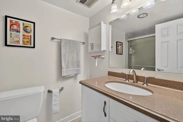 a bathroom with a granite countertop sink toilet and shower