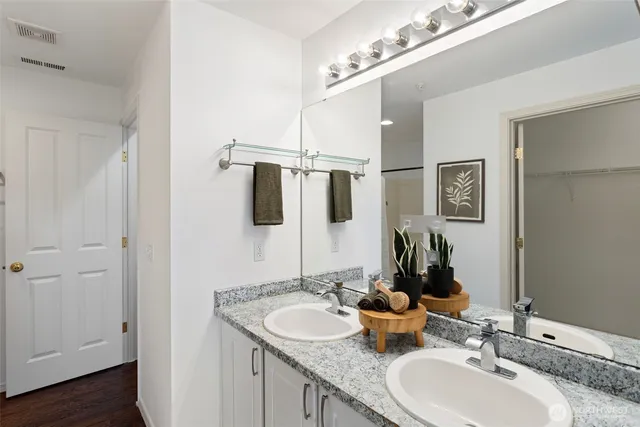 a bathroom with double vanity sinks and a mirror