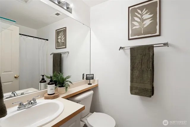 a bathroom with a toilet sink and mirror