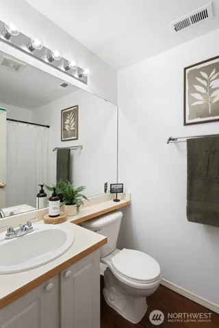 a bathroom with a toilet sink and mirror