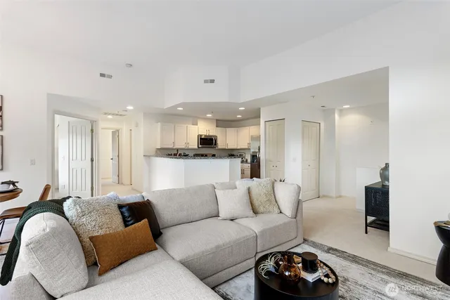 a living room with furniture white walls and a view of kitchen