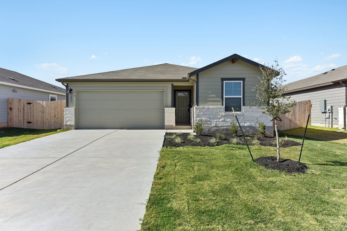 Single story home with stone siding, concrete driveway, an attached garage, and a shingled roof