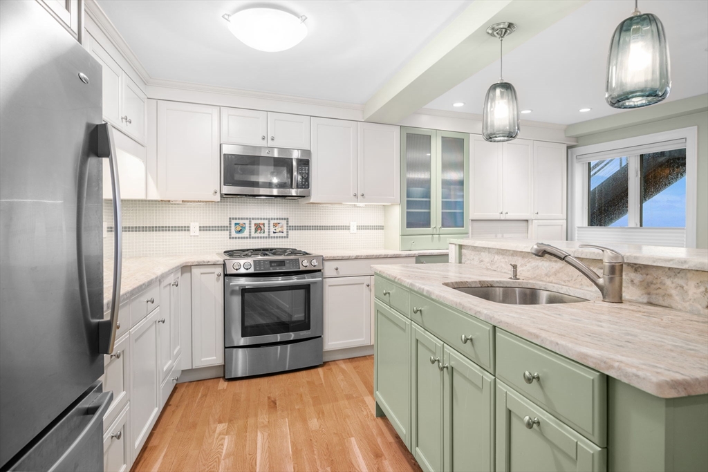 24 Lee Street, Unit B10 Marblehead, MA 01945 - Photo 24 of 33 a kitchen with stainless steel appliances granite countertop a sink stove and refrigerator