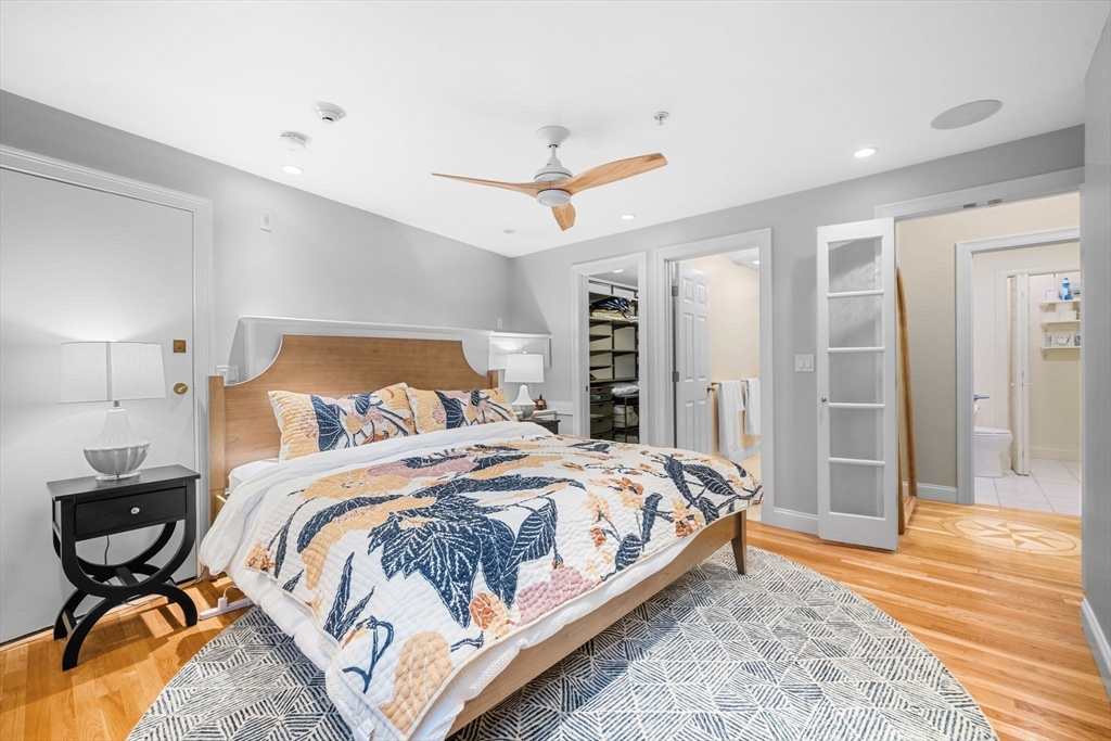 24 Lee Street, Unit B10 Marblehead, MA 01945 - Photo 28 of 33 a bedroom with a bed and dresser with wooden floor