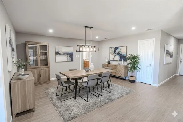 a dining room with furniture a chandelier and wooden floor