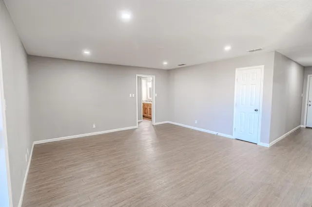 a view of an empty room with wooden floor